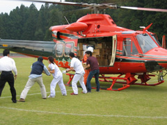 十日町病院へ運ぶ医薬品をヘリコプターから降ろす県職員（笹山陸上競技場　撮影日 H16.10.25.